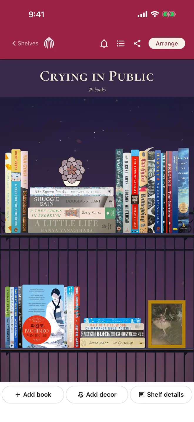 The Crying in Public shelf with standing and stacked book spines, a plant, and a framed painting